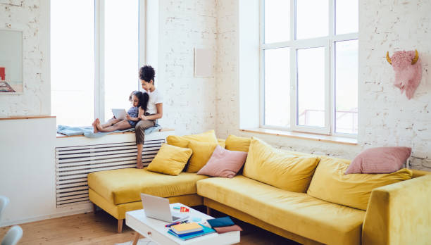 istock Daughter and mother on windowsill with tablet 1436182512
