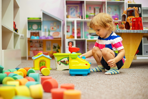 Child playing with colorful toys at the learning center or in kindergarten.