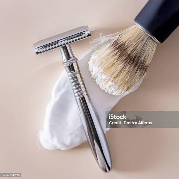 A Shaving Brush With Smeared Shaving Foam And A Tshaped Shaving Machine On A Beige Background Stock Photo - Download Image Now