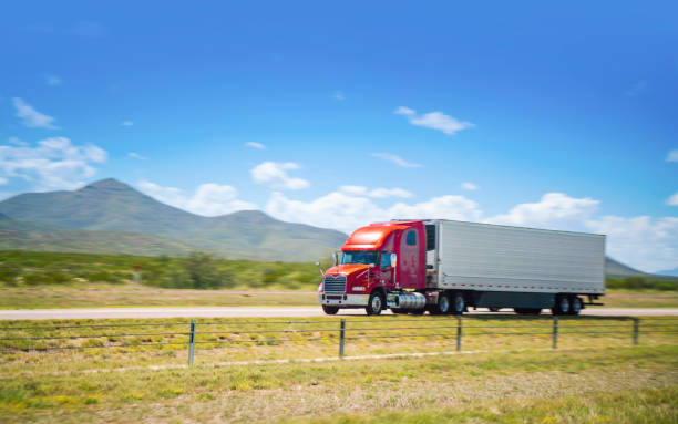 istock Red and white semi driving on a rural highway in Texas 1436185089