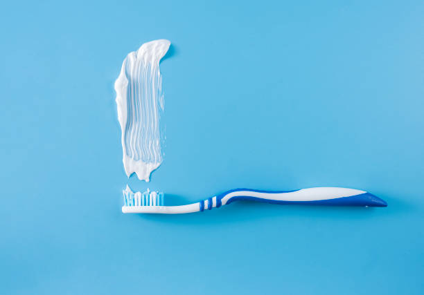 istock a toothbrush with a little smeared toothpaste and white toothpaste smeared on a blue background. 1436185135