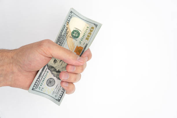 istock Hand and dollars isolated on white backgrounds 1436185695