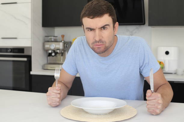 Impatient looking man waiting for dinner stock photo