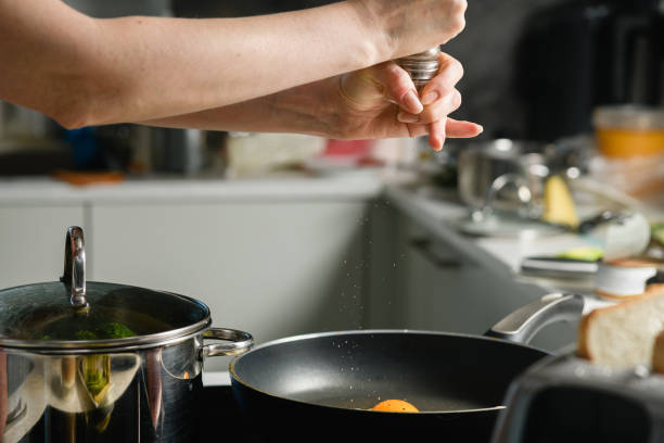 istock Woman throws salt on fried eggs on pan. 1436185912
