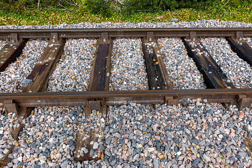 Close up of railroad tracks and sleepers filled with gravel in England.