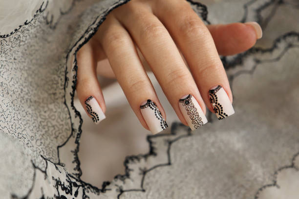 Nude manicure with graphic patterns and rhinestones on the square shape of nails.