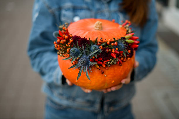 istock bright orange pumpkin with thistle, red pepper, berries and chrysanthemums. Decor for thanksgiving and halloween. 1436188358