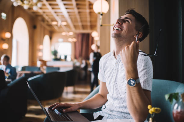 istock Young man with laptop laughing in cafe 1436189690