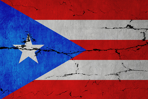 Puerto Rican Flag on cracked wall background.