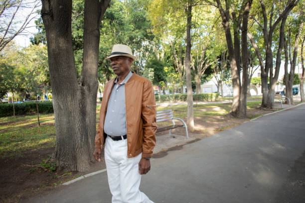 istock older man walking in the park 1436195429