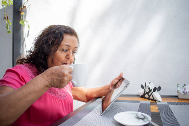 istock older woman in cafeteria using digital tablet 1436195745