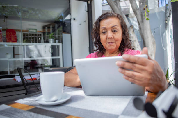 istock older woman in cafeteria using digital tablet 1436195760