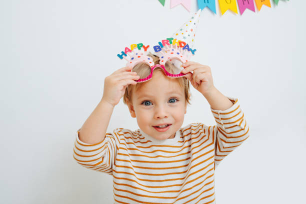 istock Cute little boy holding a wrapped present nox, wearing funny glasses. 1436195835