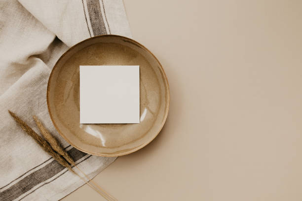 istock Brown plate with a white paper card on a linen napkin. 1436198826