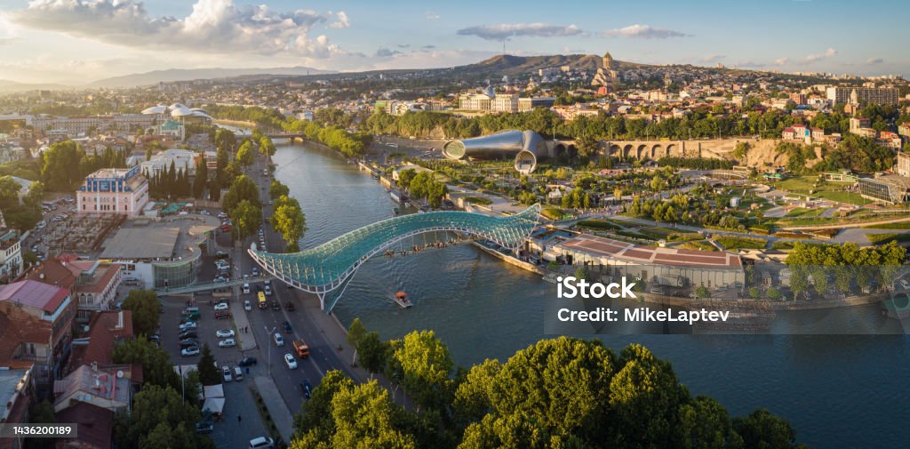 Panorama of the center of Tbilisi from the air Aerial view of downtown Tbilisi, Georgia. In the foreground is the Peace Bridge over the Mtkvari River. Tbilisi Stock Photo