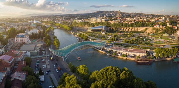 Panorama of the center of Tbilisi from the air Aerial view of downtown Tbilisi, Georgia. In the foreground is the Peace Bridge over the Mtkvari River. georgia landscape stock pictures, royalty-free photos & images
