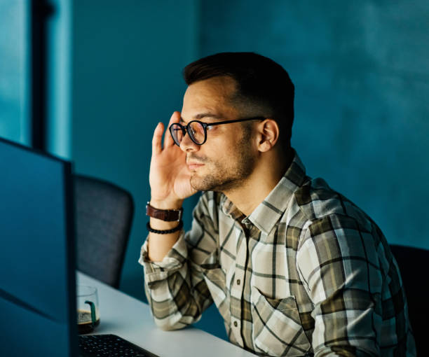 istock businessman working late night business computer man office technology light dark young internet deadline work 1436200242