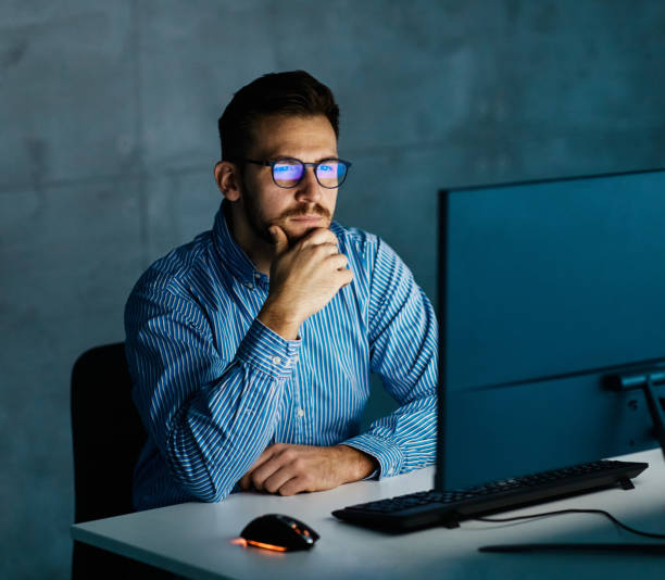 istock businessman working late night business computer man office technology light dark young internet deadline work 1436200772