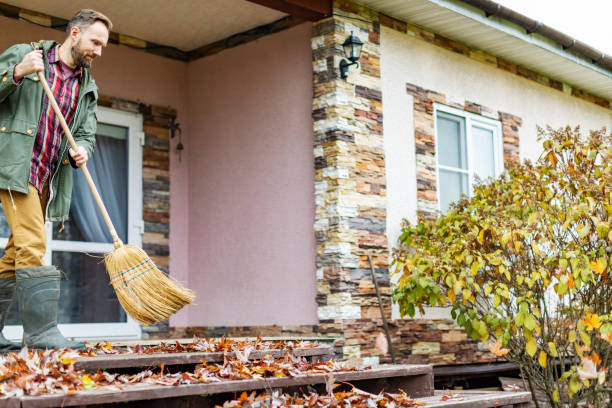 istock Adult man sweeping leaves from porch using broom 1436203022
