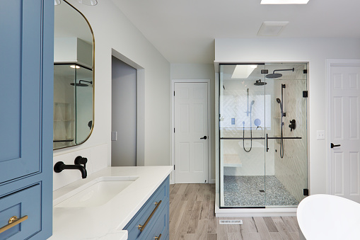 A contemporary modern bathroom design. featuring a contemporary classic freestanding porcelain bathtub and shower stall,