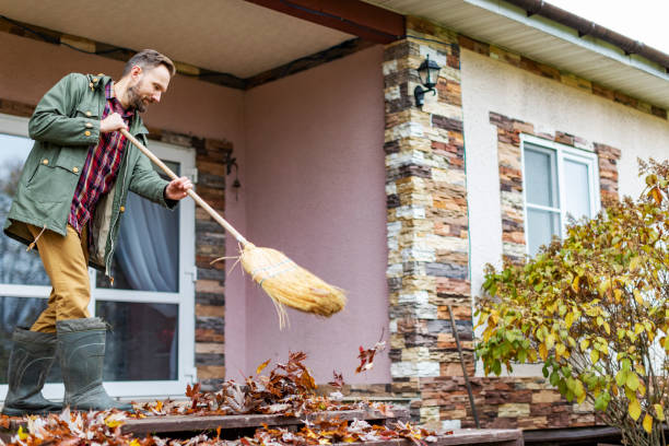 istock Adult man sweeping leaves from porch using broom 1436203741