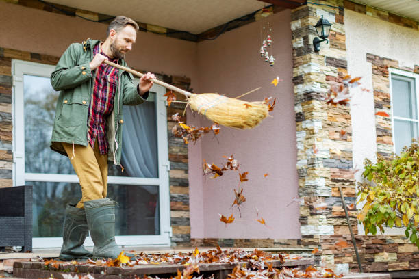 istock Adult man sweeping leaves from porch using broom 1436203774