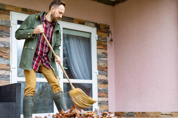 istock Adult man sweeping leaves from porch using broom 1436203803
