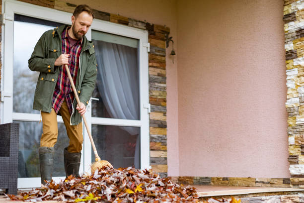 istock Adult man sweeping leaves from porch using broom 1436203808