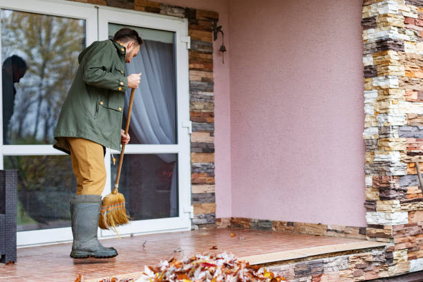 istock Adult man sweeping leaves from porch using broom 1436203809