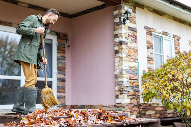istock Adult man sweeping leaves from porch using broom 1436203815