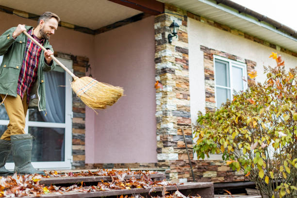 istock Adult man sweeping leaves from porch using broom 1436203839