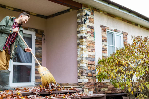 istock Adult man sweeping leaves from porch using broom 1436203853