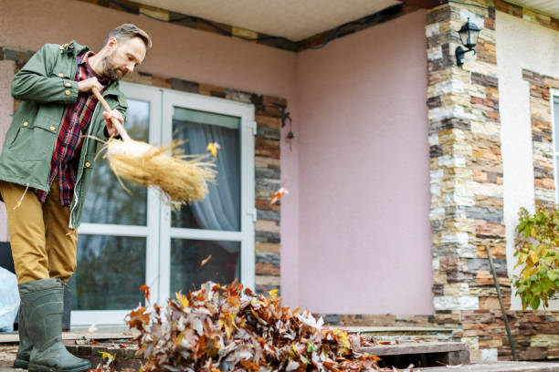 istock Adult man sweeping leaves from porch using broom 1436203925