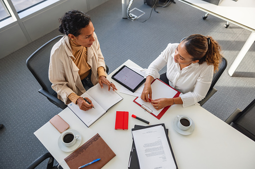 Two Confident Hispanic White Collar Workers Meeting In The Board Room And Discussing Business