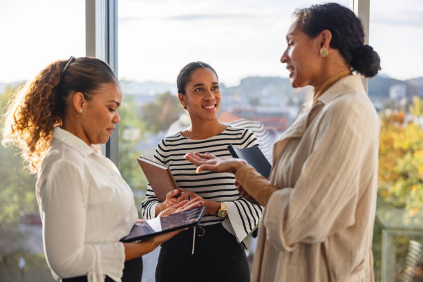 istock Smiling Group Of Female Business Professionals Talking And Laughing While Taking A Short Break 1436206779