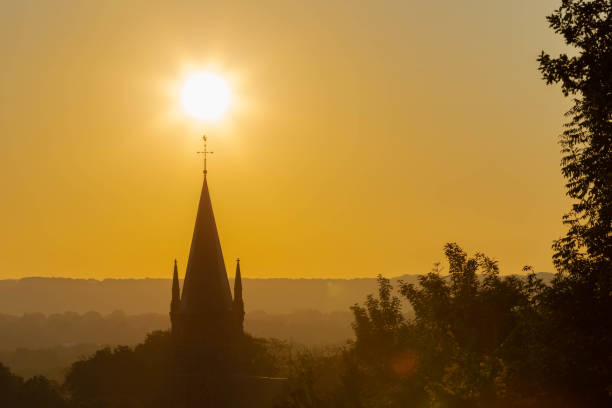 un amanecer de otoño en maastricht con la silueta de la torre de la iglesia de sint pieter - cross autumn sky beauty in nature fotografías e imágenes de stock