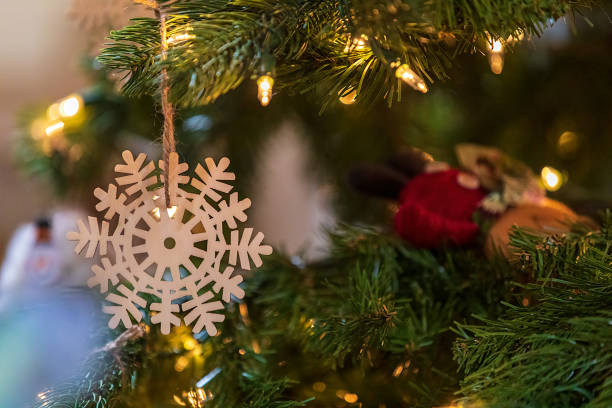 istock Wooden snowflake ornament on a Christmas tree 1436210535