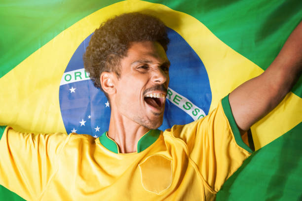 istock Black Man Holding Brazil Flag Behind Celebrating 1436210680