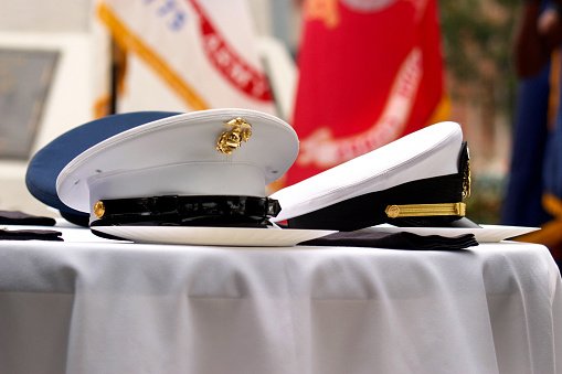 Horizontal close-up with detail of peaked military caps at the US Military table ceremony commemorating Memorial Day in the United States of America.