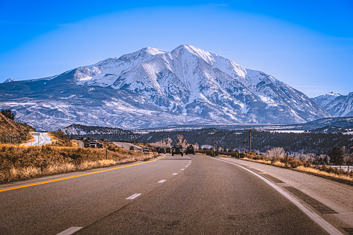 View of Colorado highway leading to beautiful snowcapped mountain