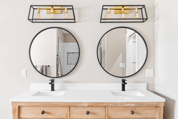 istock A bathroom with a wood cabinet and circular mirrors. 1436216738