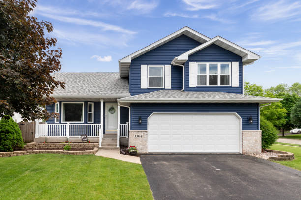 Exterior of a blue suburban home. Exterior of a suburban home with blue siding, a white front porch, and white shutters. residential district stock pictures, royalty-free photos & images