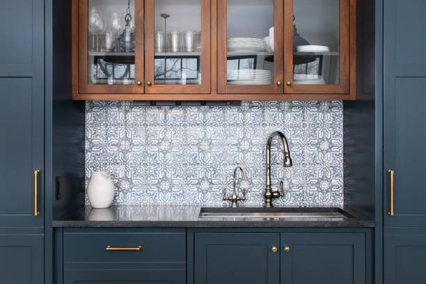 eine küche mit blauen schränken und mosaikfliesen backsplash. - granite travel stock-fotos und bilder