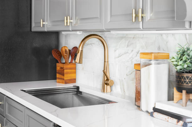 istock A grey kitchen with a gold faucet and marble subway tile. 1436217089