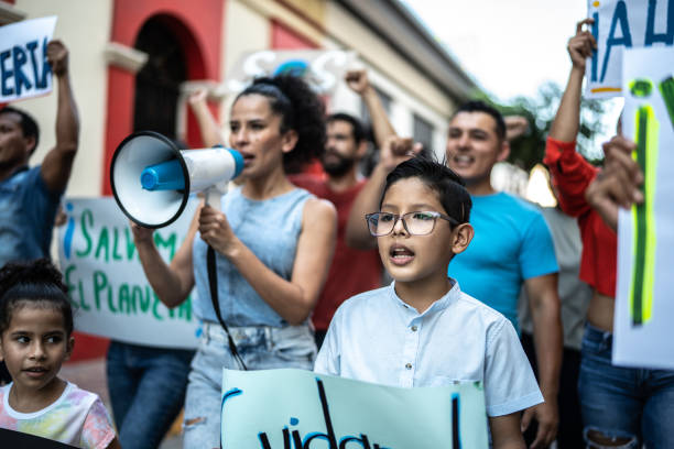 istock Child boy walking while holding a sign on a protest outdoors 1436218750