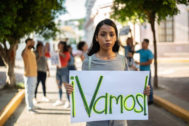Portrait of young woman holding sign on a protest outdoors Portrait of young woman holding sign on a protest outdoors climate justice stock pictures, royalty-free photos & images