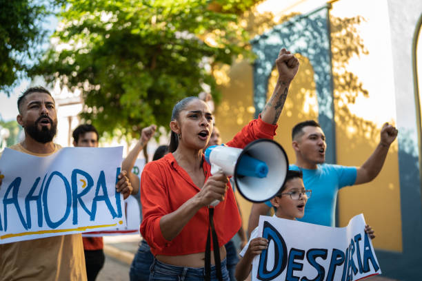 istock Mid adult protester woman leading a demonstration using a megaphone 1436219174