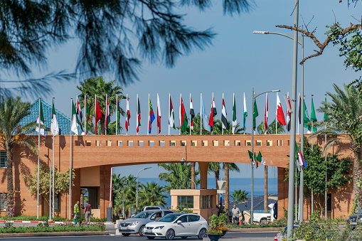 Algiers, Algeria - October 24, 2022: Arab league countries flags near Staoueli Club of Pines and Sahel state residence. Sea and trees and a sunny blue sky.