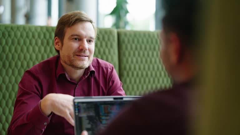 Mature businessman talking with male colleague at restaurant