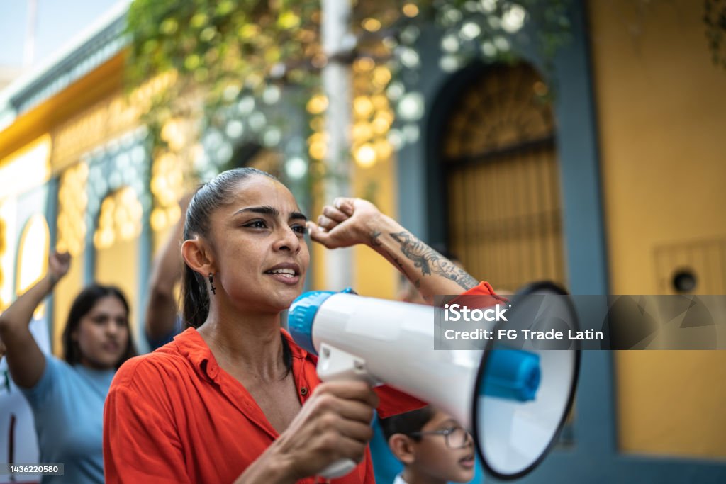 Mid adult protester woman leading a demonstration using a megaphone outdoors Mexico Stock Photo
